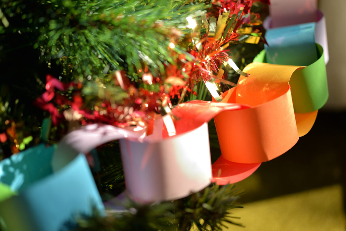 Holiday Pet Travel and Safety, Homemade rainbow paper chain on Christmas tree, with red and gold tinsel